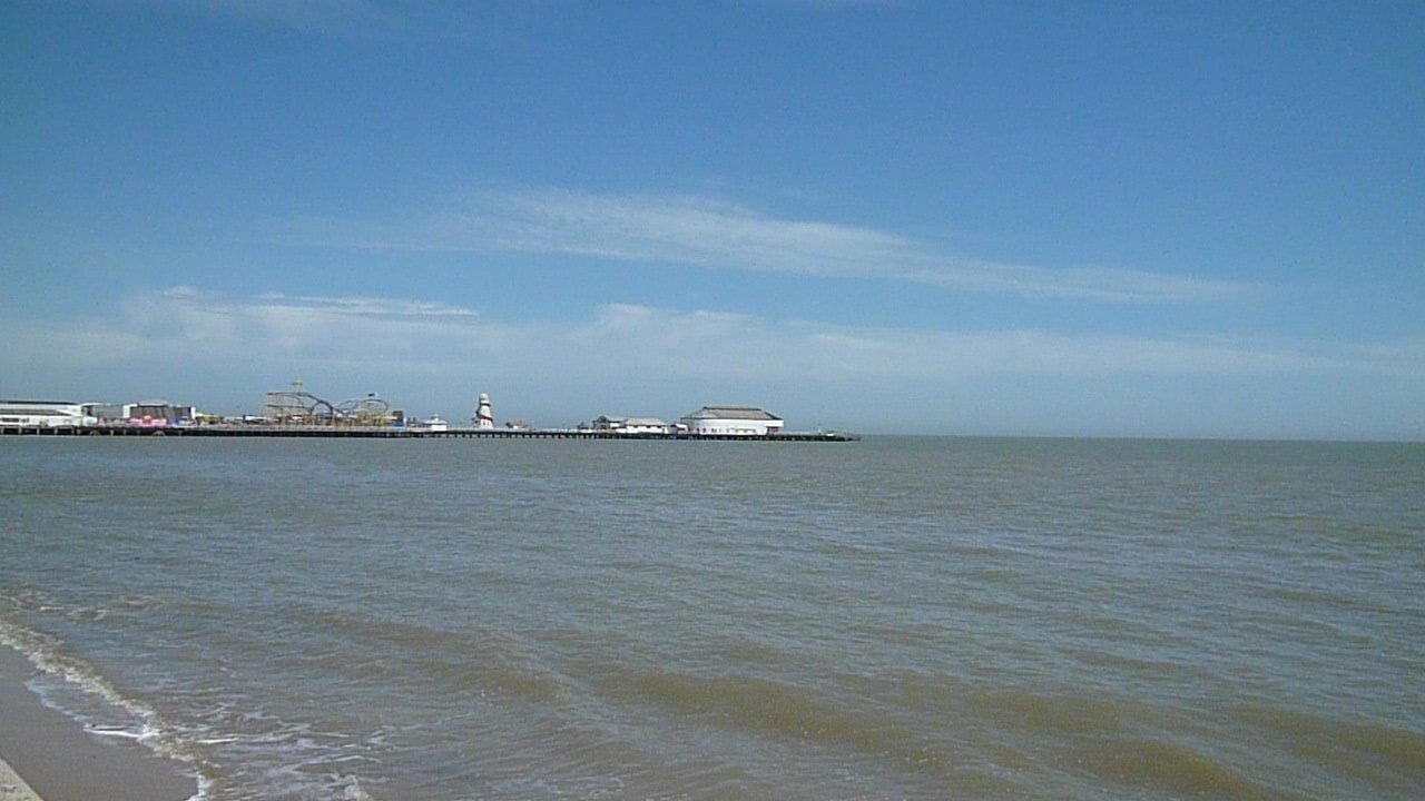 Clacton pier on the horizon in the distance, with the sea in front of it.